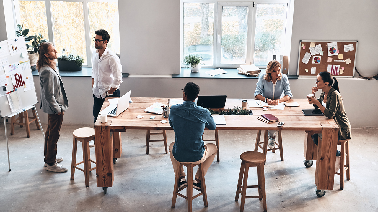 Top view of modern young people communicating while working together in the board room
