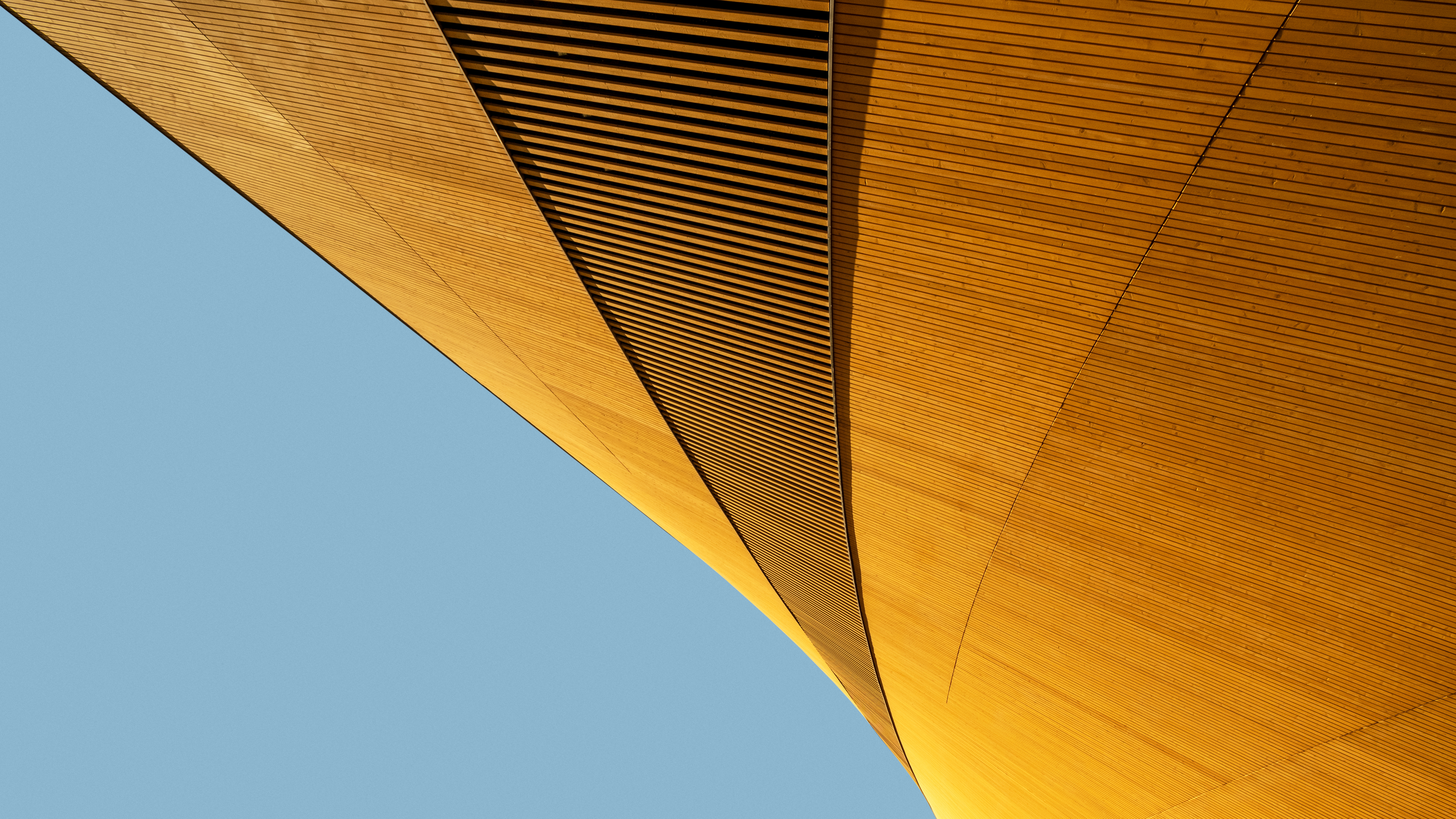 Abstract shape of modern wooden building against blue background, elegant minimalist geometric architecture