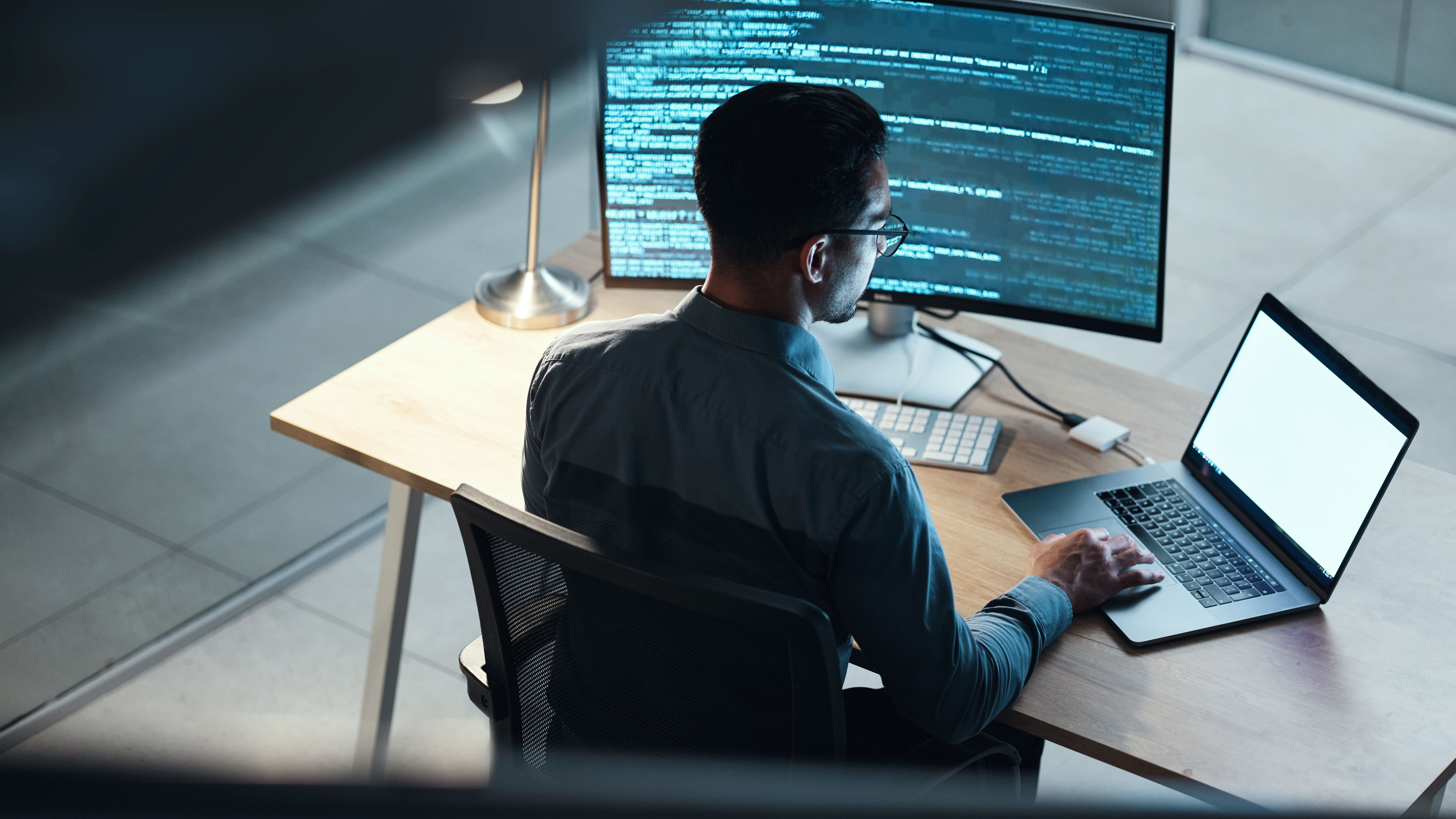 Man, programmer and coding at night on laptop mockup screen for networking, malware or software at the office. Male person, coder or developer working late in computer display in problem solving.