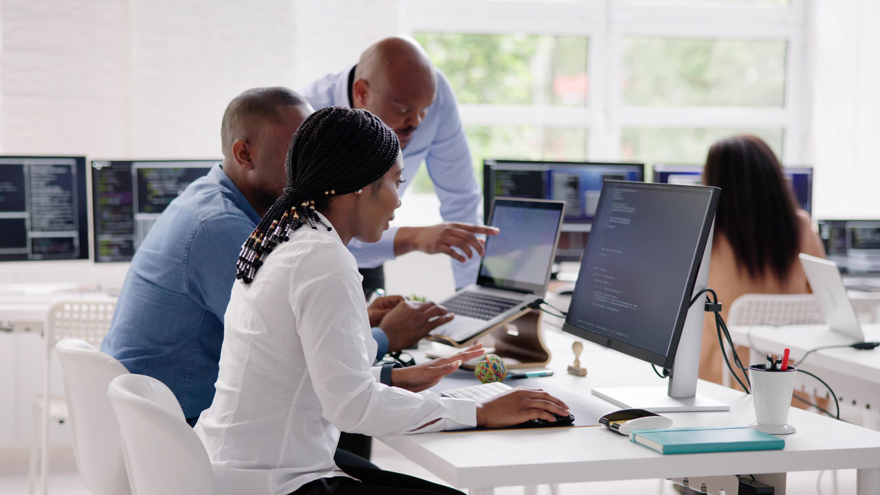 African Business Team Working On Computer. Software App Development