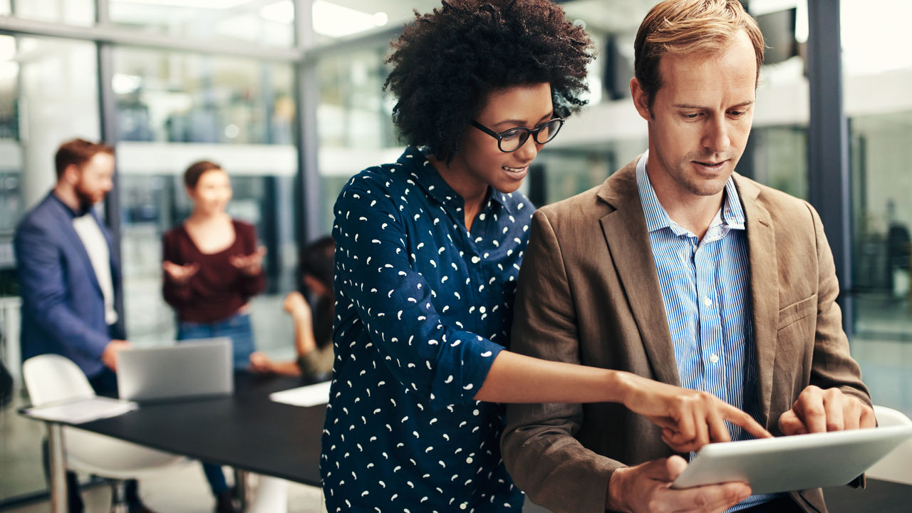 646457564Shot of two colleagues using a digital tablet together during a meeting at work 16X9
